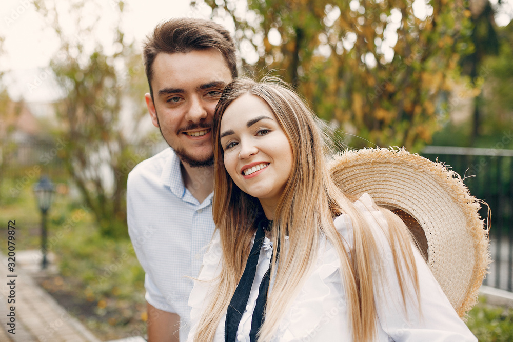 Obraz premium Cute couple in a park. Lady in a white dress. Guy in a white shirt