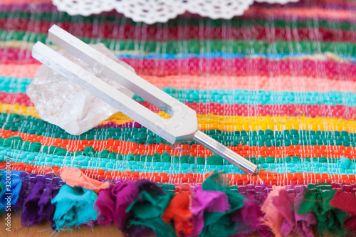 Hand holding a tuning fork and crystal stone  .