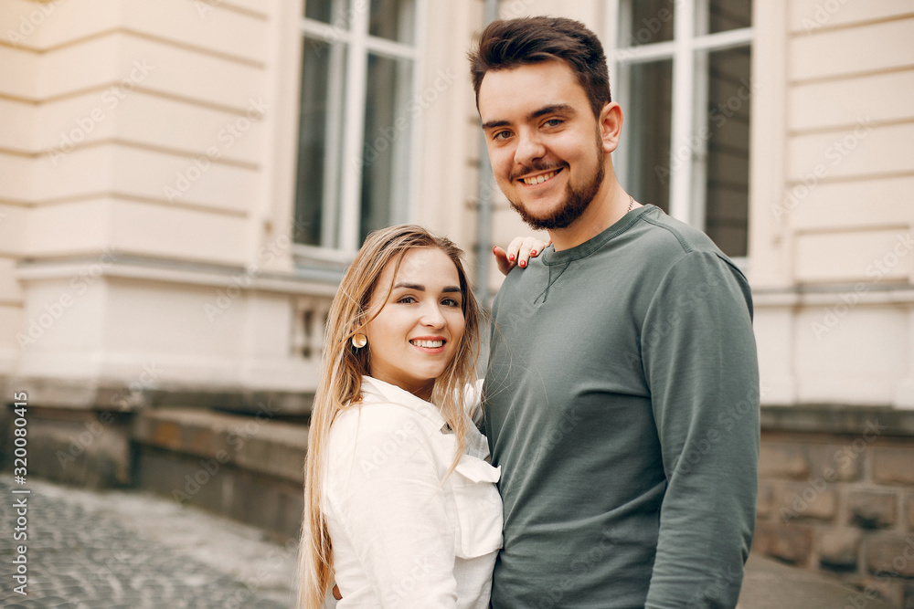 Cute couple in a city. Lady in a white blouse. Guy in a green sweater Cute couple in a city. Lady in a white blouse. Guy in a green sweater