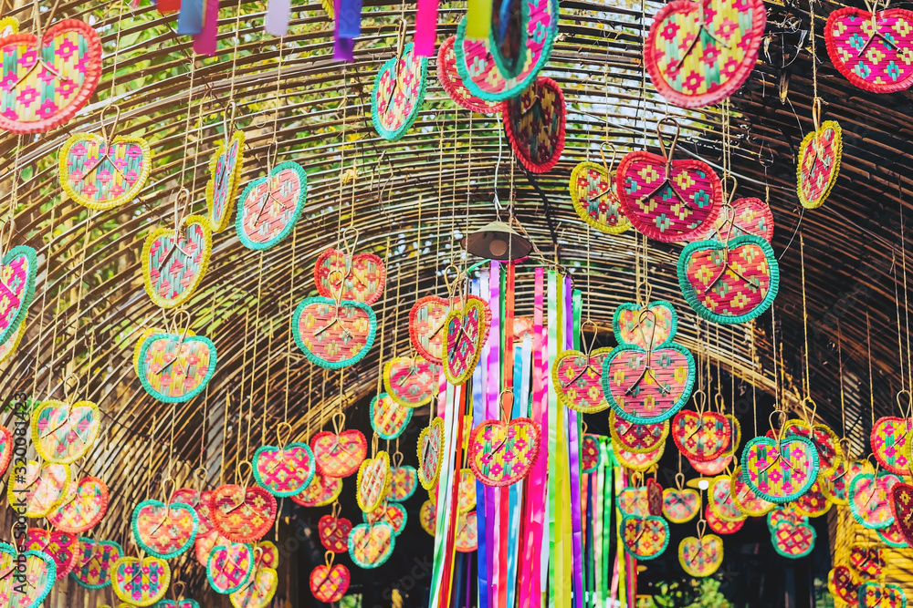 Many colorful of fanning woven from bamboo are hung above to decorate the walkway in the annual happiness festival in public park. Selective focus.