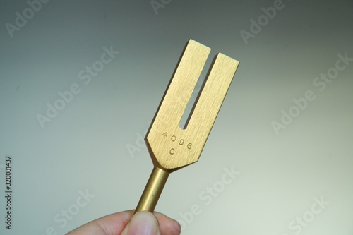 Hand holding a tuning fork .