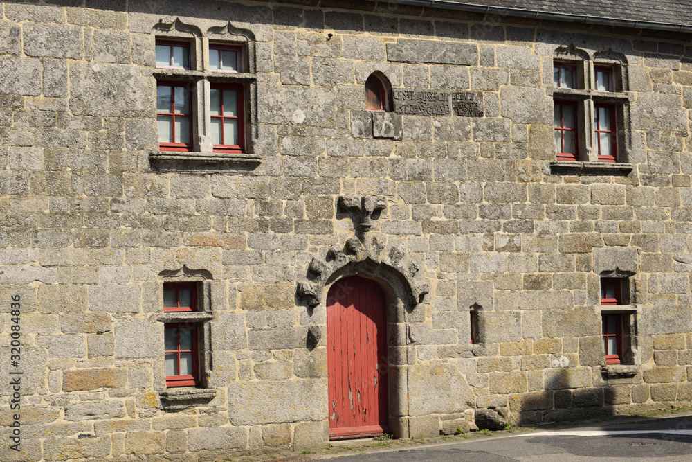 Typique architecture bretonne pour cette façade en pierres de maison ancienne en Bretagne fenêtre à meneaux et sculptures