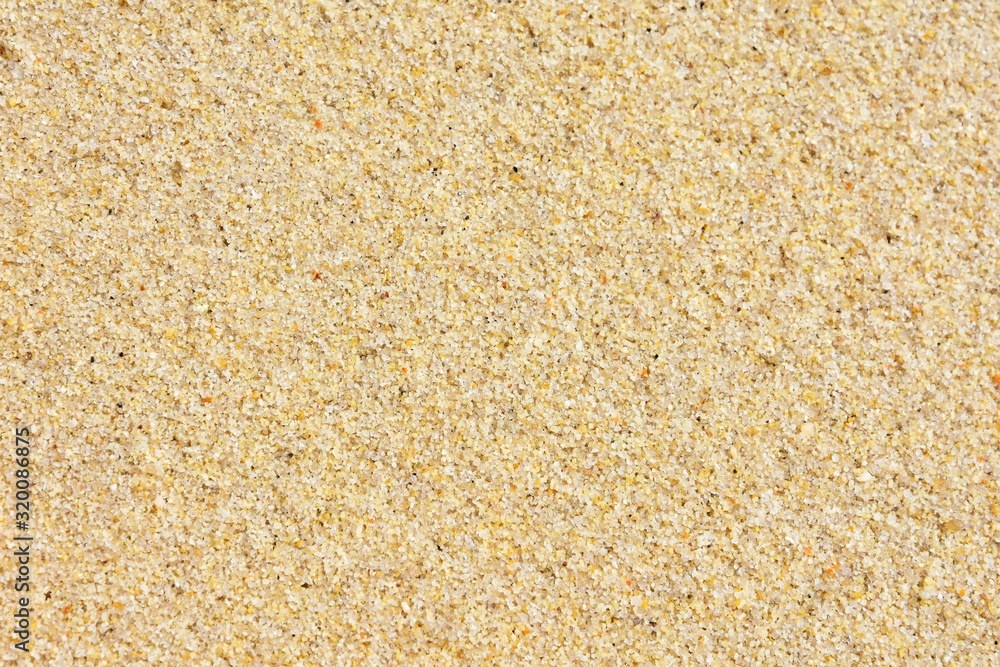 Golden wet sand background with selective focus. Textured yellow sand surface with soft focus. Summertime. Beach vacation. Seascape with clean sand. Golden wet sand background with selective focus. Textured yellow sand surface with soft focus. Summertime. Beach vacation. Seascape with clean sand.