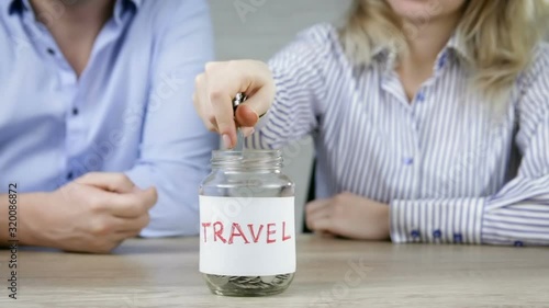Young man  and woman throwing coins in moneybox for travel. Concept is saving money to travel.