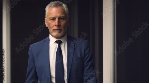 The handsome old businessman walking indoor. slow motion