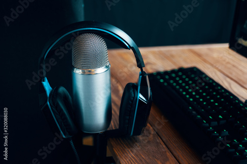 Podcast studio. Photo of a professional microphone with .headphones near computer. Close up. photo