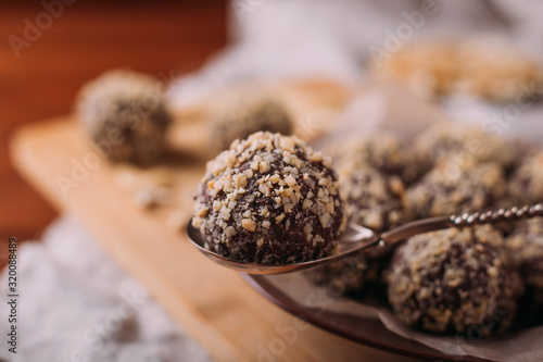 Cocoa balls, chocolate truffles cakes on board on wooden background