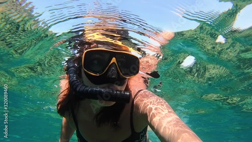 A woman traveler underwater in the sea in a mask for snorkeling swims underwater, the underwater world of the Thai Sea, the Andaman Sea, a woman blogger under the floating slow motion.