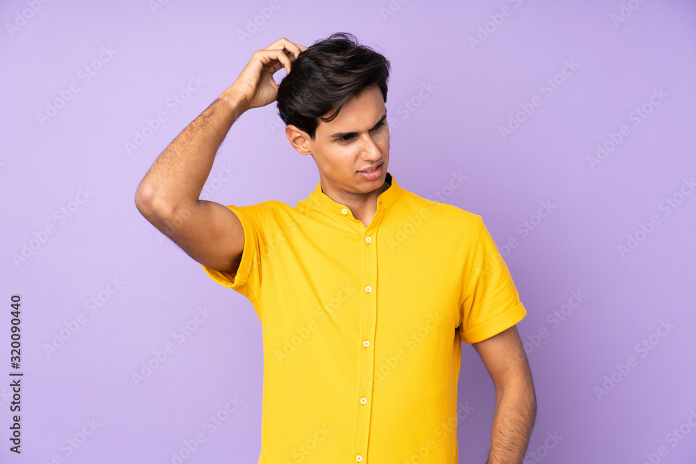 Man over isolated purple background having doubts while scratching head Man over isolated purple background having doubts while scratching head