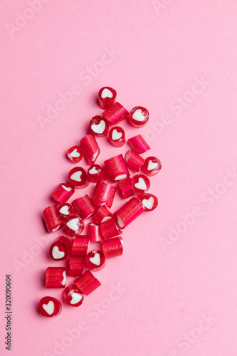 Colorful Valentines Day candy hearts on pink background