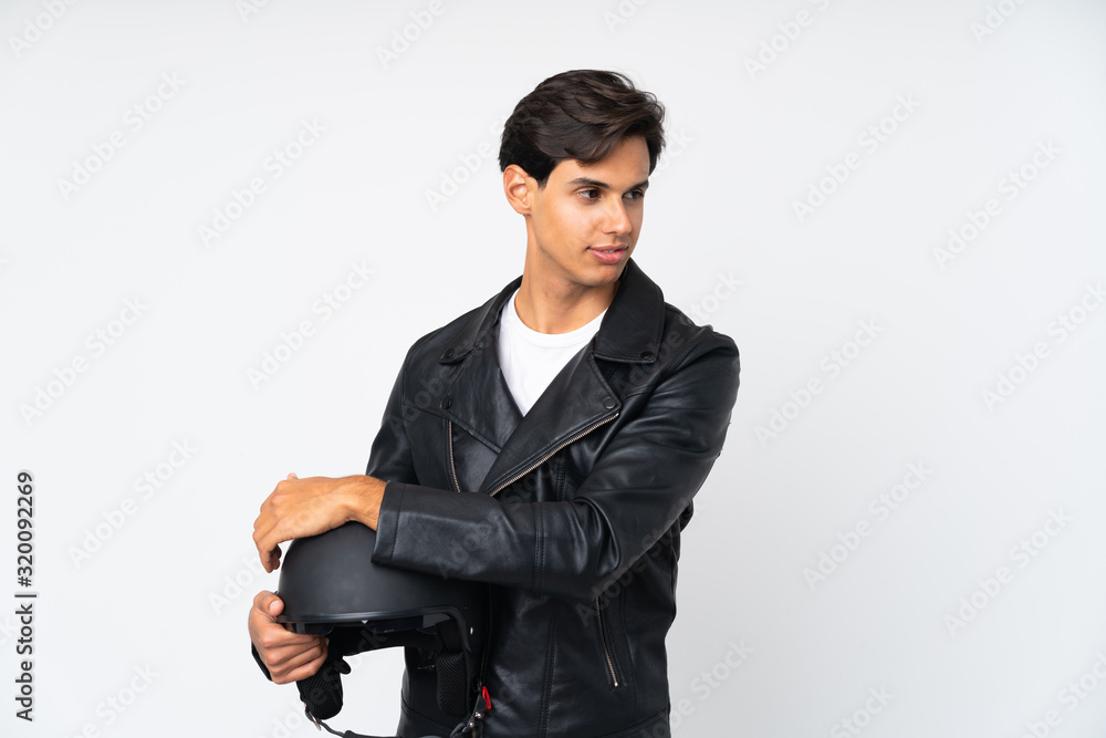 Man holding a motorcycle helmet over isolated white background thinking an idea Man holding a motorcycle helmet over isolated white background thinking an idea