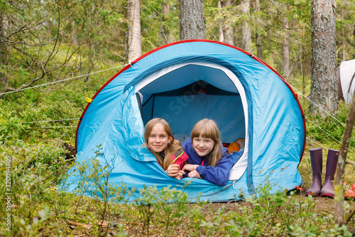 Girls lying together in a tent enjoying summer holidays