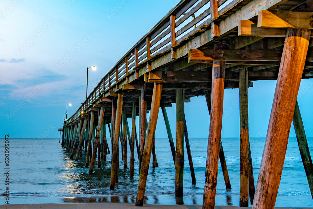 Wooden pier into the ocean in Virginia Beach at sunrise Wooden pier into the ocean in Virginia Beach at sunrise