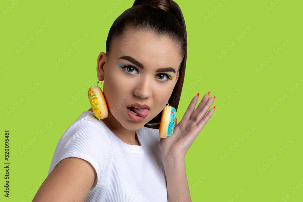 Portrait of a beautiful young woman with donuts earrings and bright make-up Portrait of a beautiful young woman with donuts earrings and bright make-up