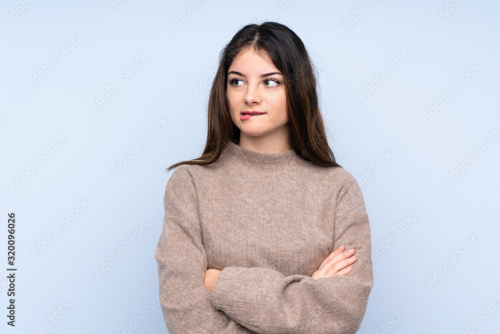 Young brunette woman wearing a sweater over isolated blue background with confuse face expression Young brunette woman wearing a sweater over isolated blue background with confuse face expression