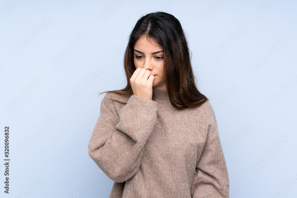 Young brunette woman wearing a sweater over isolated blue background having doubts Young brunette woman wearing a sweater over isolated blue background having doubts