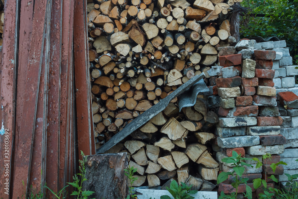 Old painted boards, firewood, and brick lie in the back yard Old painted boards, firewood, and brick lie in the back yard