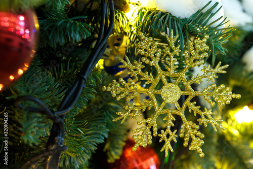 Fototapeta Naklejka Na Ścianę i Meble -  Golden snowflake on a christmas tree, closeup.