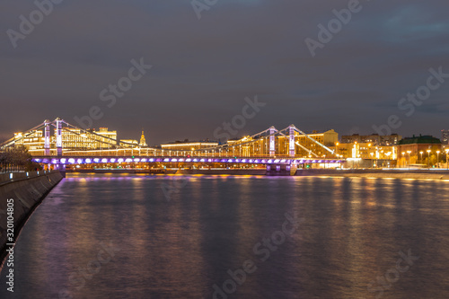 Glowing bridge over the river. The far plan. Moscow night