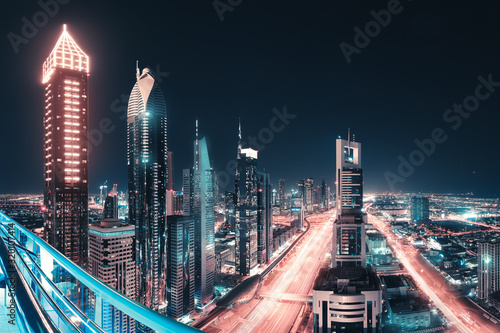 Night view of the spectacular landscape of Dubai with high-rises and skyscrapers at the Sheikh Zayed highway. Global travel destinations and real estate concept