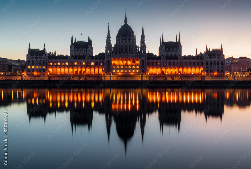 Partly illuminated facade of Budapest Parliament during blue hour