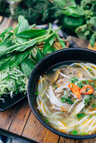 Fresh organic Vietnamese Pho Bo noodle soup with herbs on the side