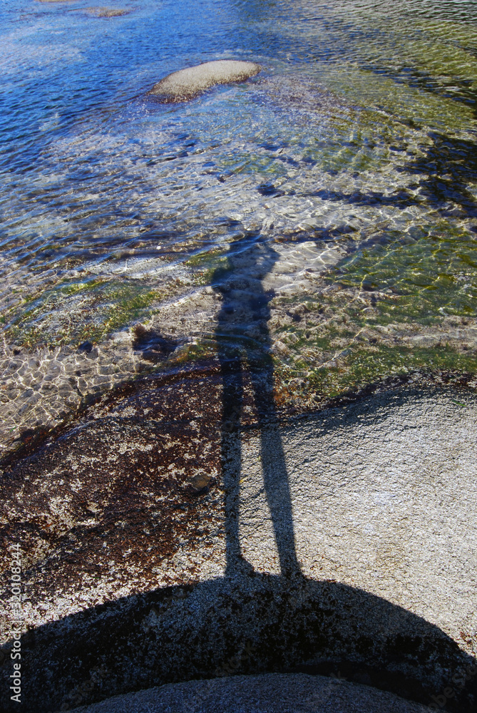 Shadow of a girl standing on a seashore. Taking photo of a shadow. Tropical island. Pacific ocean. Shadow of a girl standing on a seashore. Taking photo of a shadow. Tropical island. Pacific ocean.
