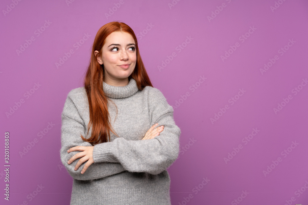 Fototapeta premium Redhead teenager girl over isolated purple background standing and looking to the side
