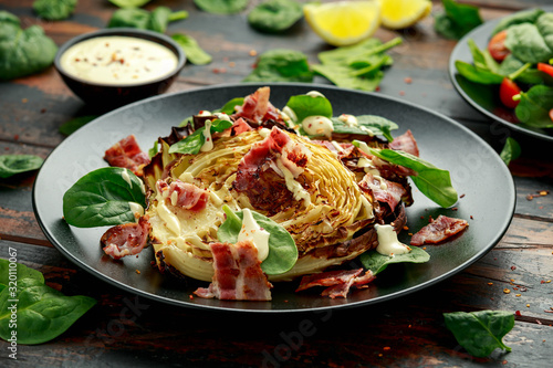 Oven roasted cabbage steaks with bacon, spinach and mayonnaise. healthy food