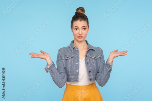 I don't know, who cares. Portrait of confused clueless uncertain woman with hair bun in fashionable clothes shrugging shoulders with careless indifferent expression, gesturing whatever. studio shot photo