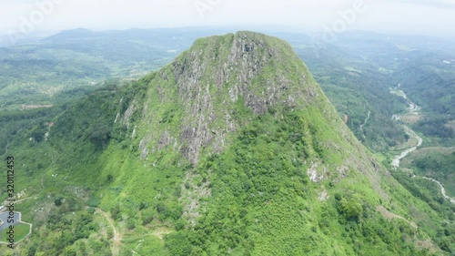 Beautiful aerial scenery of tropical hill with green scrub and fog at misty morning. Shot in 4k resolution from a drone flying to right photo