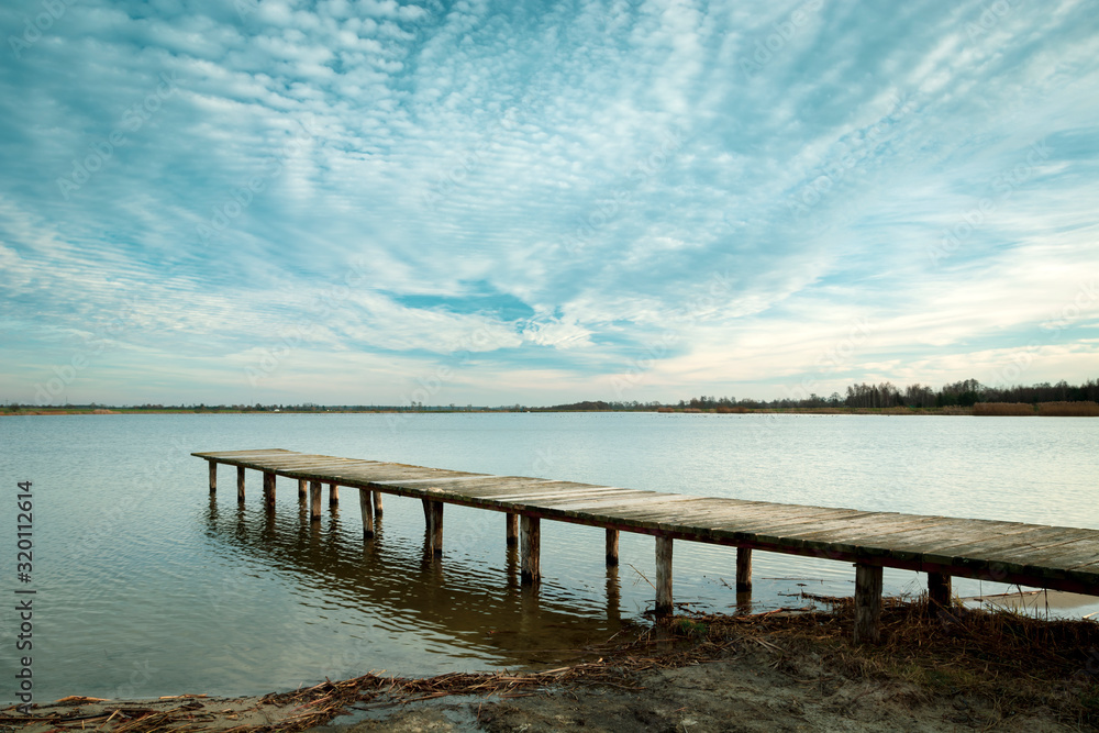 A long wooden bridge on the water and cloudscape, Staw, Poland