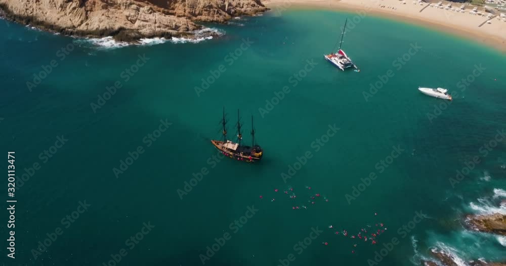 Panning Drone Shot of People Swimming off the Coast with Resort and Landscape Background in Cabo, Mexico Panning Drone Shot of People Swimming off the Coast with Resort and Landscape Background in Cabo, Mexico
