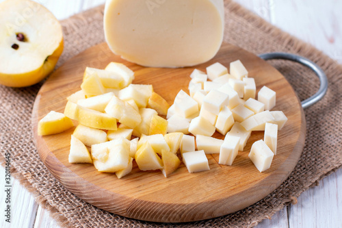 Cheese and apple cubes on a cutting board