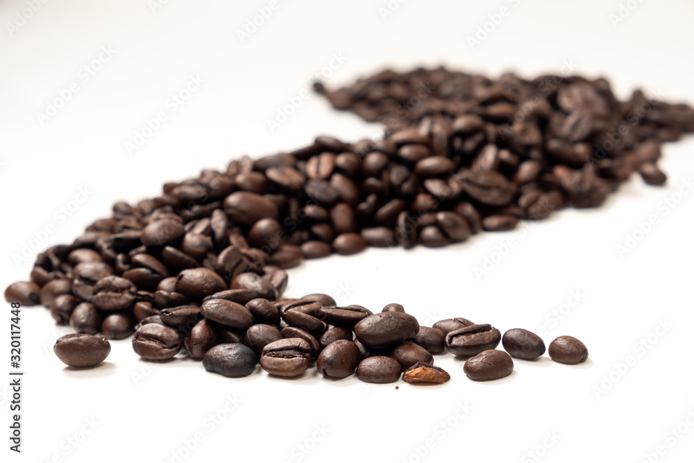 A trail of coffee beans on a white background