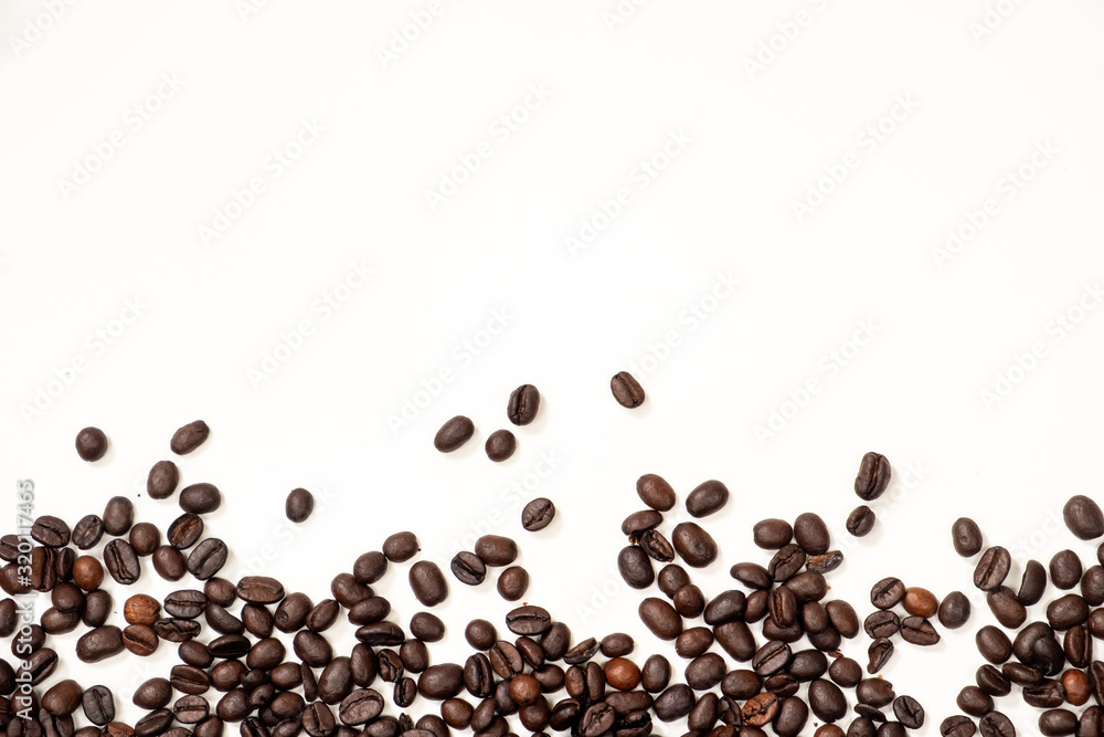 Brown coffee beans scattered downstairs on a white background Brown coffee beans scattered downstairs on a white background