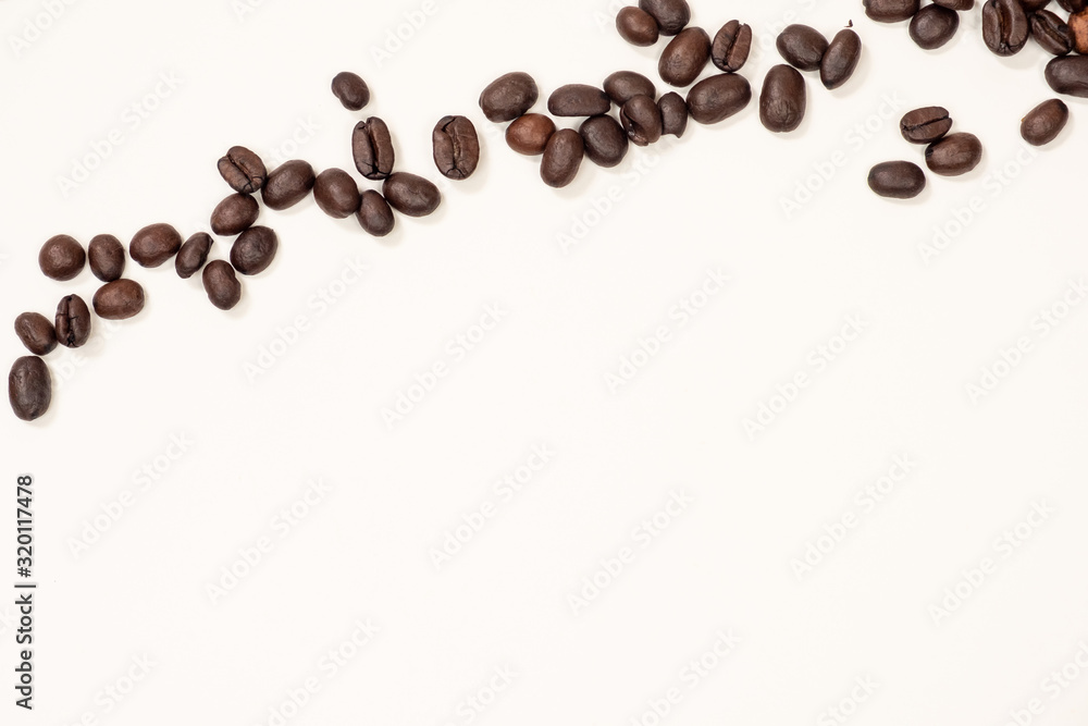Brown coffee beans on top of a white background Brown coffee beans on top of a white background