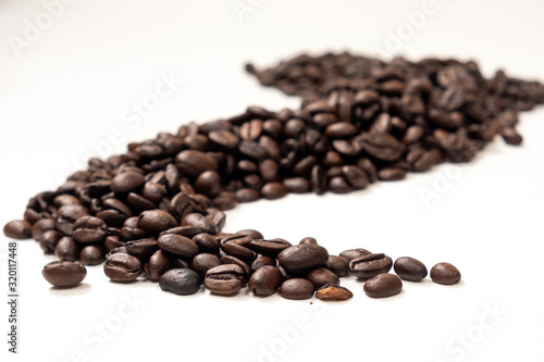 A trail of coffee beans on a white background