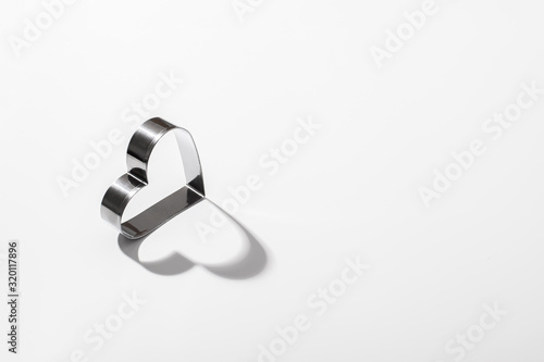 Fototapeta Naklejka Na Ścianę i Meble -  Concept for valentines day. Heart on a white background. Hard shadows. Flat lounger, top view, space for copy