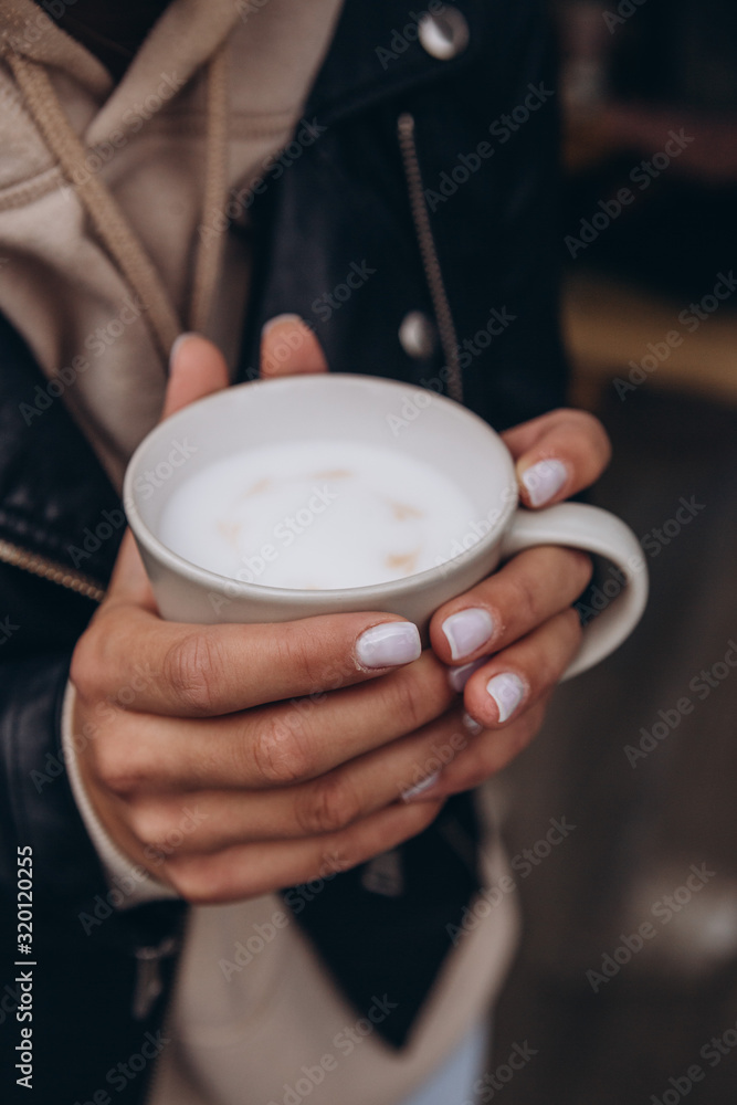 Beautiful female hands holding a mug of latte. Close up Beautiful female hands holding a mug of latte. Close up