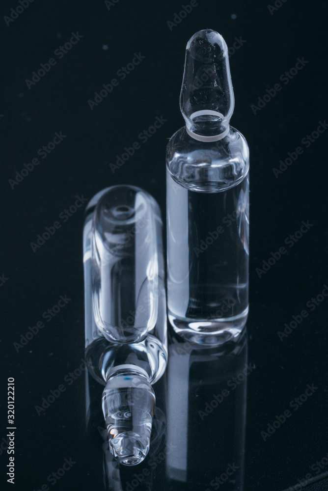 Glass medical ampoule vial for injection. Medicine is dry white drug penicillin powder or liquid with of aqueous solution in ampulla. Close up. Glass medical ampoule vial for injection. Medicine is dry white drug penicillin powder or liquid with of aqueous solution in ampulla. Close up.