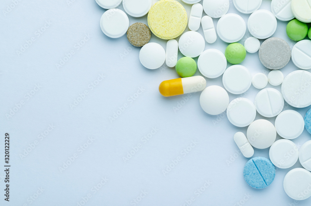 tablets of different shapes and colors on a blue background close up tablets of different shapes and colors on a blue background close up