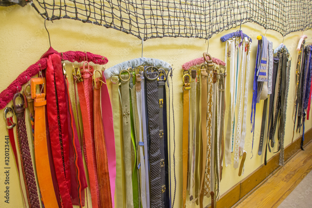 Many colorful belts hanging in theater costume room