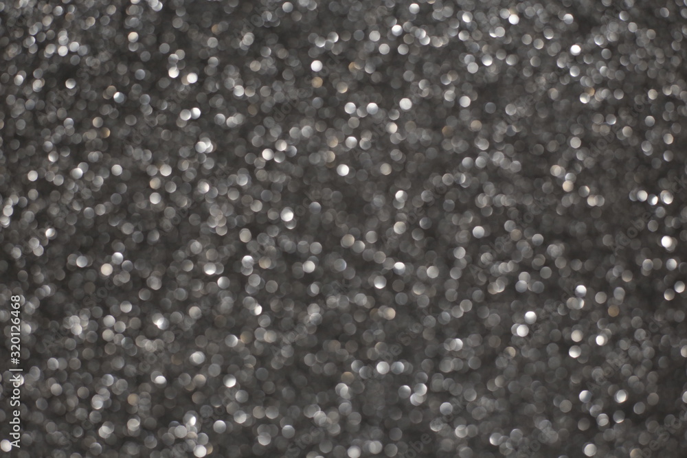 Defocused abstract gray lights background. Space. Wallpaper. Abstract glitter bokeh on black background