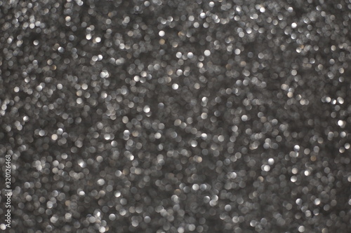 Defocused abstract gray lights background. Space. Wallpaper. Abstract glitter bokeh on black background