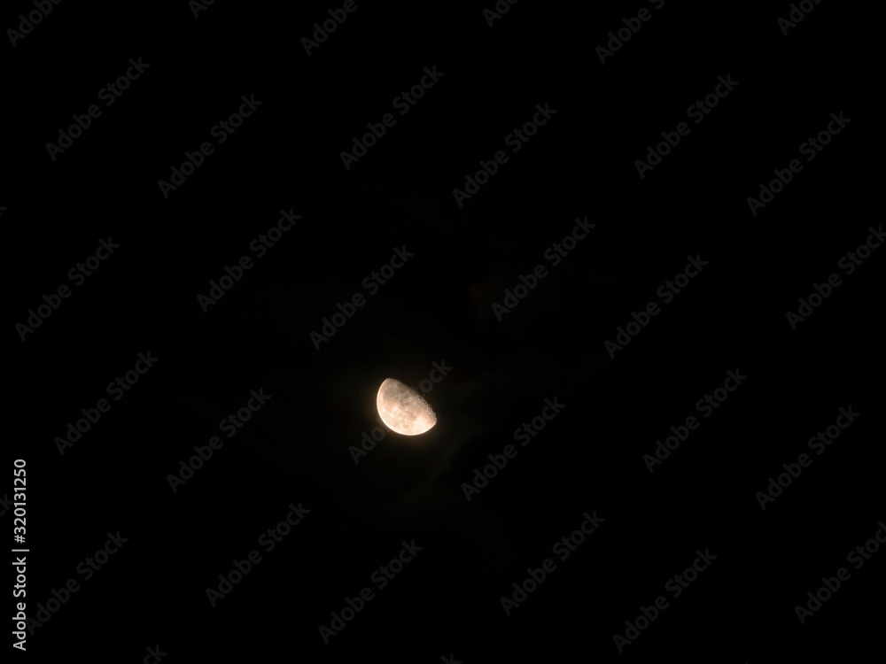 the growing moon in the dark sky