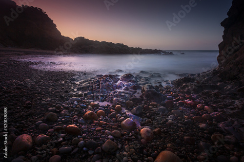 Sunrise and pebbles at Rotherslade, a small Bay in South Gower next to a more famous one, Langland Bay on the Gower peninsula in Swansea, South Wales, UK