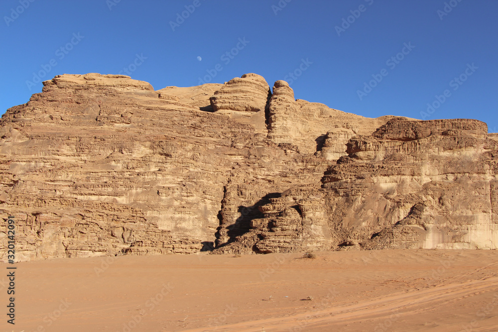 Textured sand mountains in Wadi Rum desert in Jordan. Clear blue sky. Theme of travel and safari in Jordan. Textured sand mountains in Wadi Rum desert in Jordan. Clear blue sky. Theme of travel and safari in Jordan.
