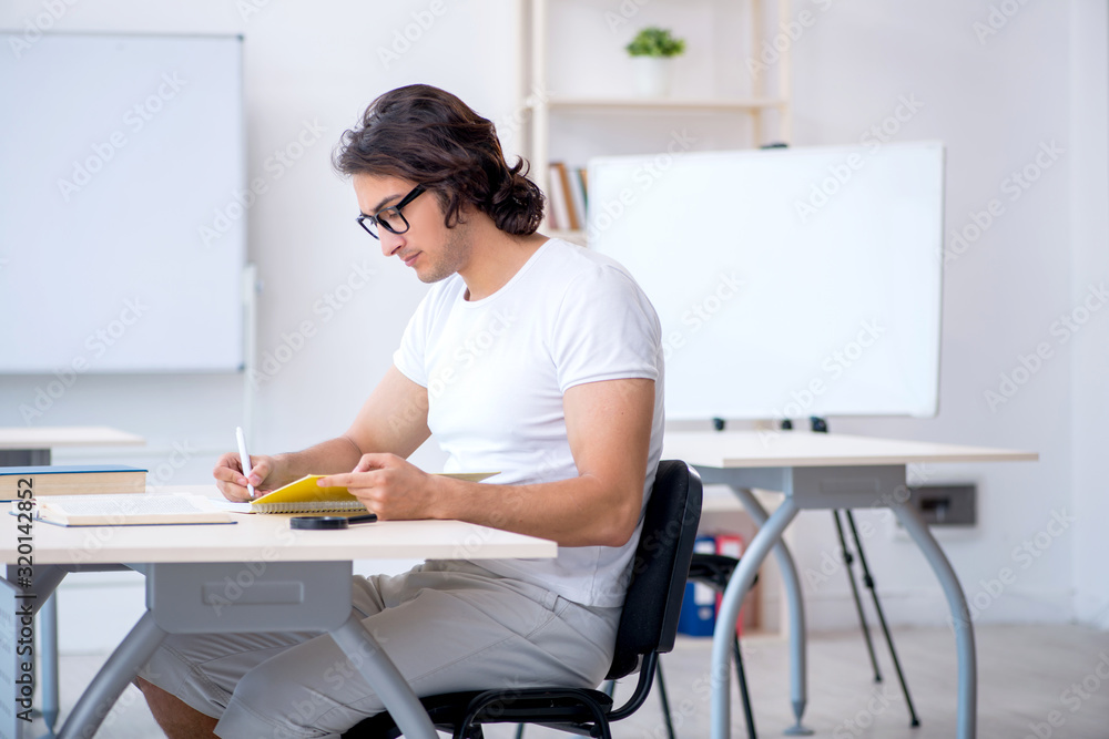Young male student in front of whiteboard Young male student in front of whiteboard