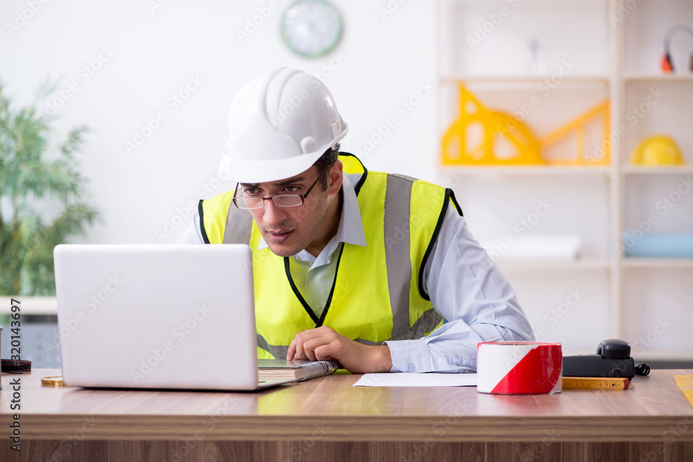 Young male architect working in the office Young male architect working in the office